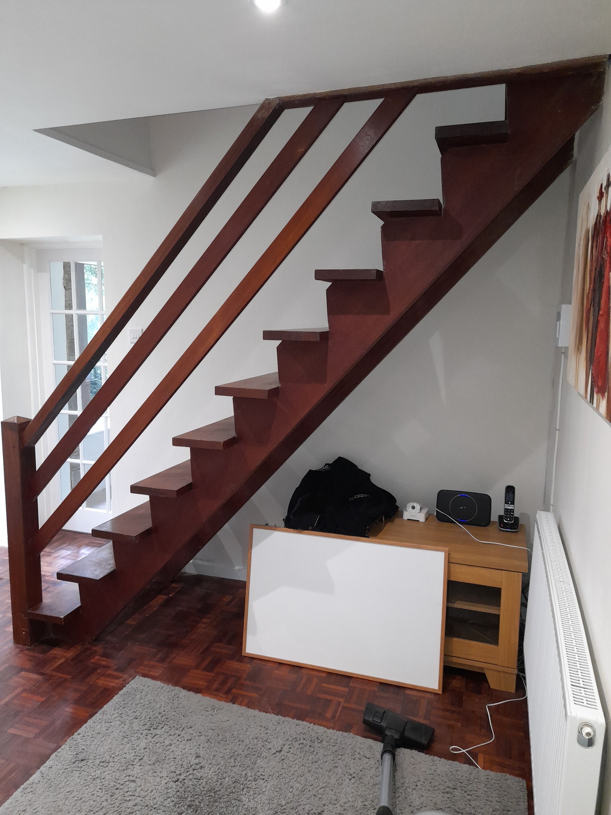 Before: a 1960s open-tread staircase with a dark timber rail