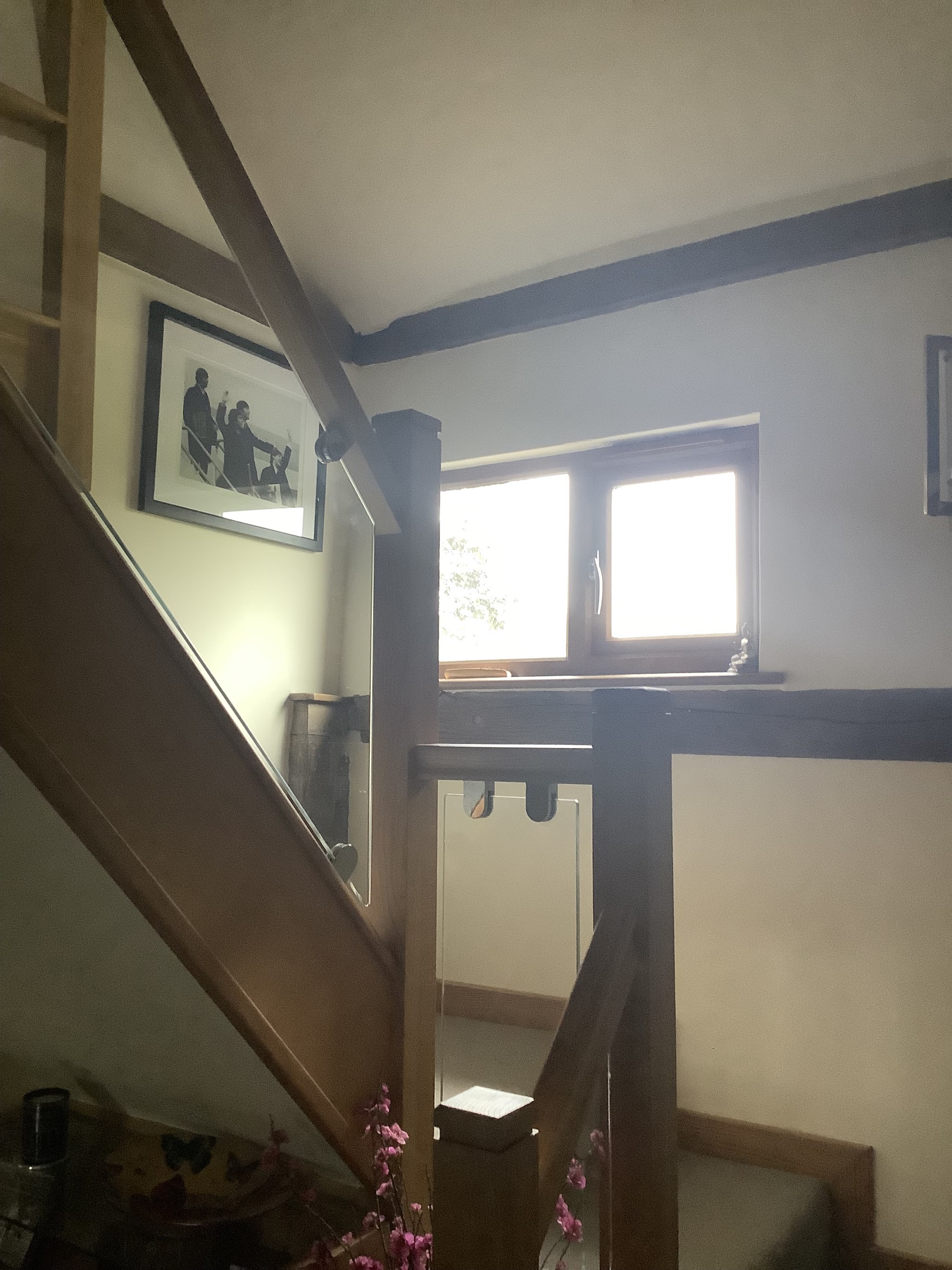 An oak and glass staircase in a cottage with exposed beams