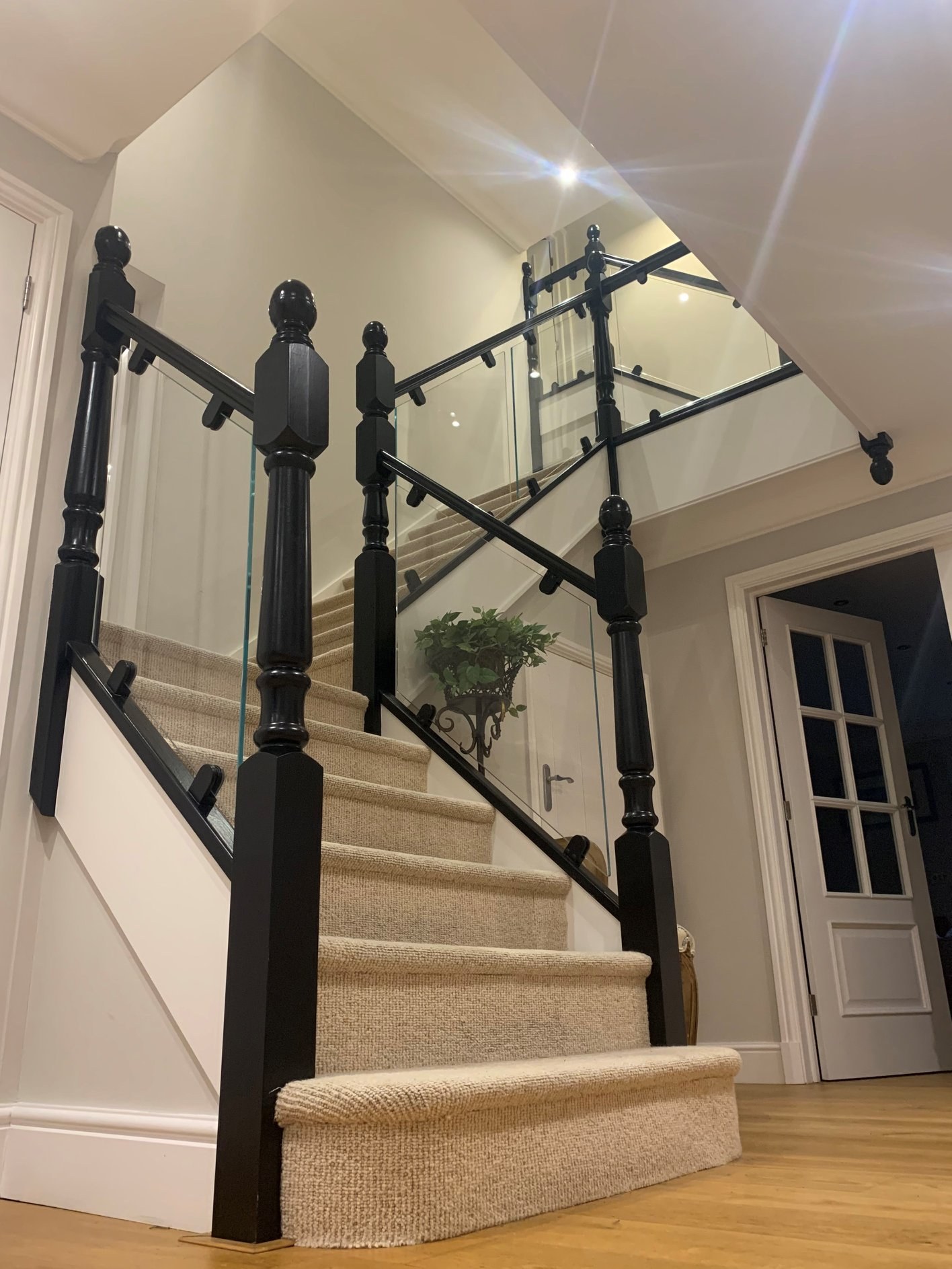 Black painted newel posts with glass panels and black metal fixings