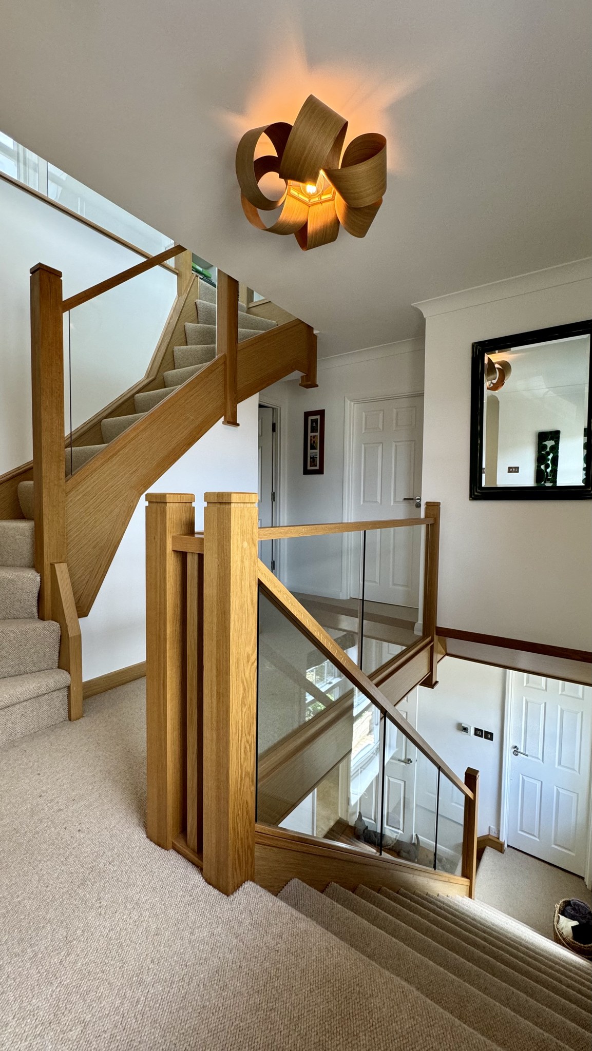 Looking down an oak and glass dog-leg staircase